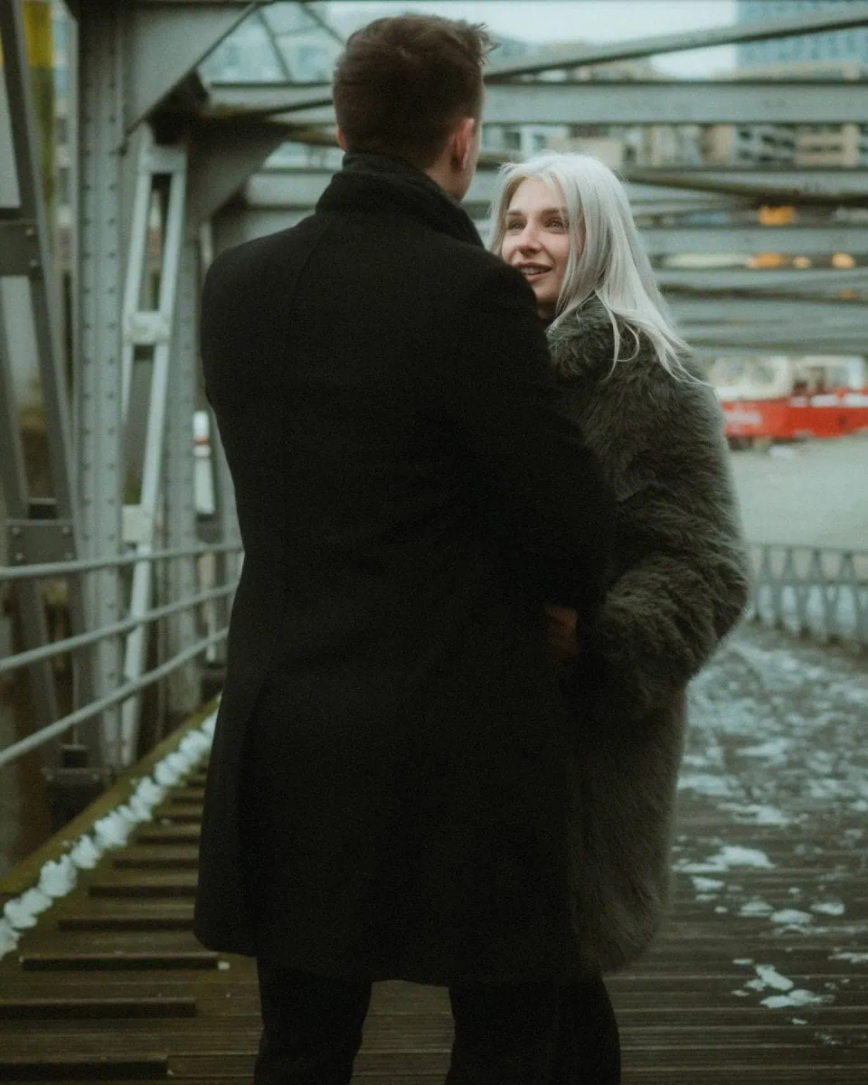 a man and woman standing on a bridge