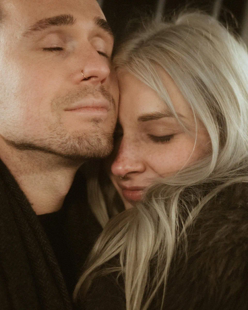 a man and woman with their eyes closed
